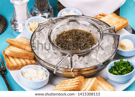 
Mediterranean caviar appetizer on ice, toast, butter, greens and a set of sauces