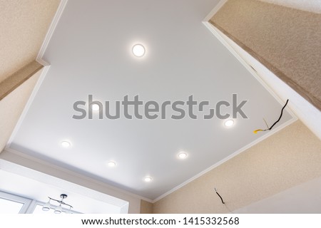 Stretch ceiling in the kitchen with installed and included spotlights Royalty-Free Stock Photo #1415332568