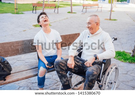 Beautiful picture of a boy hanging out with his grandfather sitting on a wheelchair