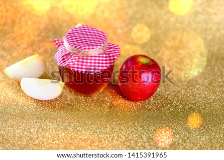 Glass jars with honey and apple on gold background. Sweet harvesting, autumn, holidays,  jam and fruit. Bank with honey, healthy food, veganism.