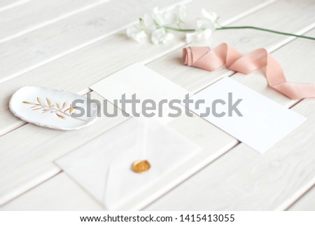 Wedding invitation birthday gift certificate for a spa or care decorated letter card on a white wooden table with a branch of white flowers