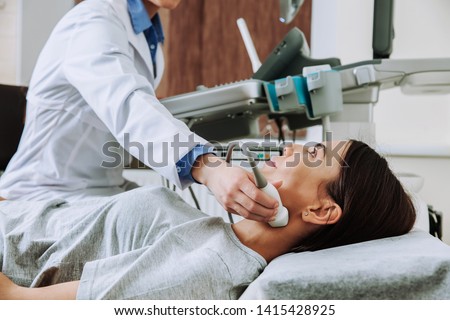 Woman undergoing ultrasound scan in clinic Royalty-Free Stock Photo #1415428925