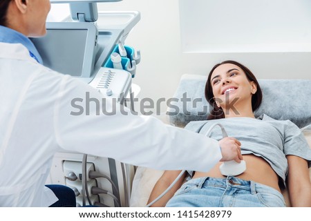 Woman undergoing ultrasound scan in clinic Royalty-Free Stock Photo #1415428979