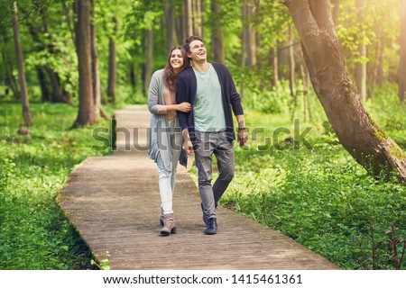 Young couple strolling in the park Royalty-Free Stock Photo #1415461361