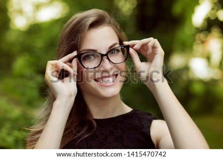 Attractive young woman wearing fashion stylish glasses outdoor in park seeing the world with new eyes 