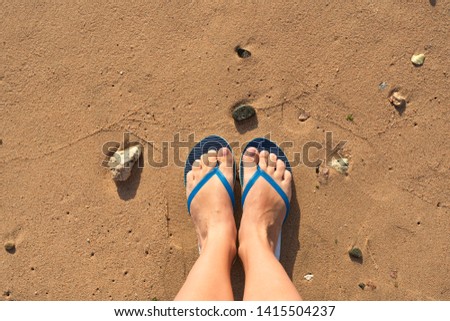 Top view of two female  legs isolated on wet sand of summer tropical beach. Happy woman enjoying summer vacations outside. Horizontal flatlay photography.