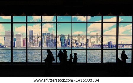 Manhattan and the East River with Instagram Effect viewed through a window with people silhouetted in the foreground