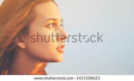 Beautiful young woman relaxing and enjoying sun at sunset. Beauty sunshine girl side profile portrait. Pretty happy lady enjoying summer outdoors. Positive emotion life success mind peace concept Royalty-Free Stock Photo #1415508623