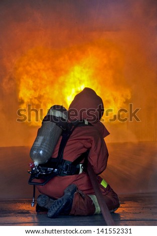 Firefighter fighting a fire during a firefighting training exercise for safety danger,Fire Insurance concept