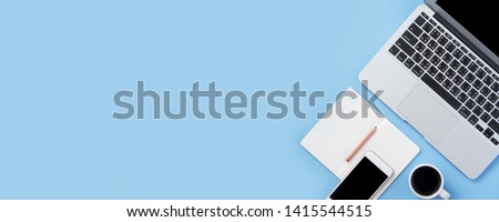 Girl write on open white book or accounting on a minimal clean light blue desk with laptop and accessories, copy space, flat lay, top view, mock up Royalty-Free Stock Photo #1415544515