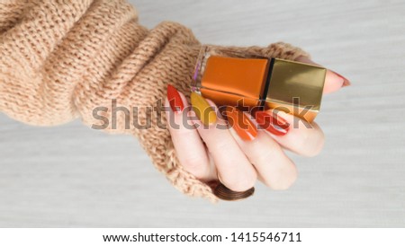 Female hands with long nails with yellow golden nail polish
