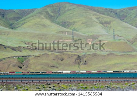 green and brown mountain, rough terrain, under blue sky