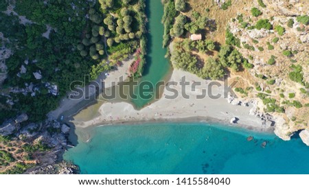 Aerial drone view of Mediterranean paradise river with palm trees flowing to sandy deep turquoise beach