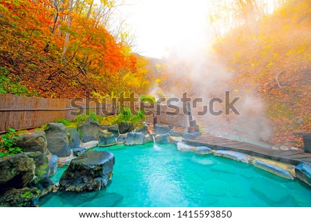 Japanese Hot Springs Onsen Natural Bath Surrounded by red-yellow leaves. In fall leaves fall in Japan.Waterfall among many foliage, In the fall leaves Leaf color change. Royalty-Free Stock Photo #1415593850