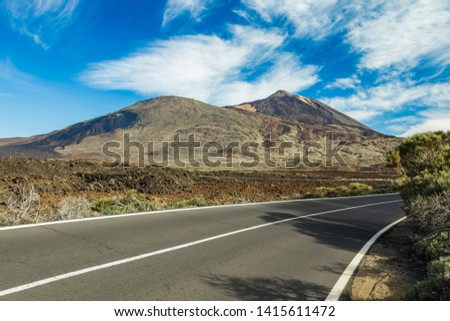 Mountain Teide, partly covered by the clouds. Bright blue sky. Teide National Park, Tenerife, Canary Islands, Spain.