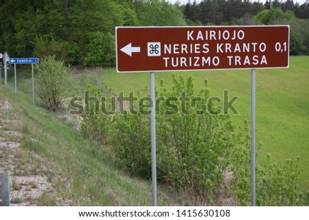 Road sign at foreground. Some Lithuania landscape in background. Date May 15, 2019. Camera Canon 5D.