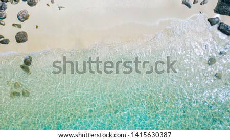 Aerial drone shot of beautiful paradise sand with rock beach with clear turquoise sea. Summer and travel vacation concept