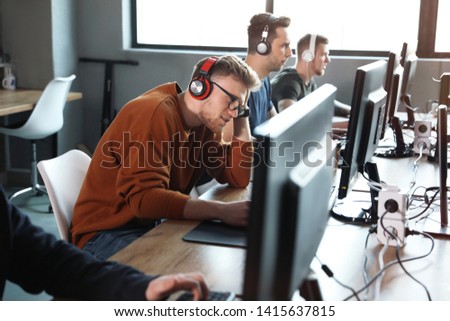 Men playing video games in internet cafe