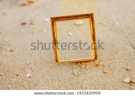 vintage gold picture frame on sand beach.