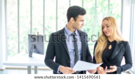 Blurred background of two office people working together in company. The successful businessmen learning about e-commerce/e business as online technology is changing. Teamwork& collaboration concept.