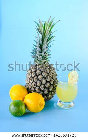 Tropic fruits and glass of fresh lemonade on blue background