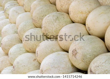closeup to stock of cantaloupe sell in market and put in layers diagonally to show its raw, ripe, round shape and texture from local organic farm.This fruit give freshness with sweet taste for food