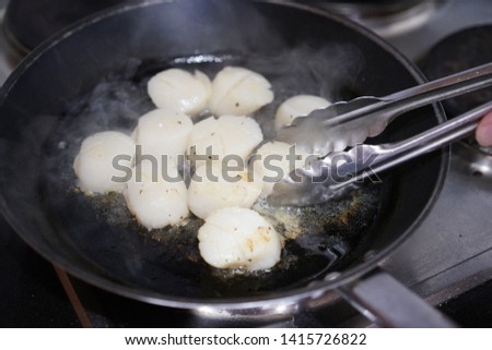 close up picture of pan fired scallops on a stove