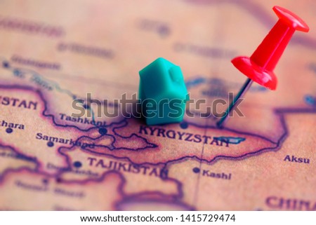 House and pushpin on Kyrgyzstan (world map). Citizenship/ residence of / residential property in Kyrgyzstan concept.