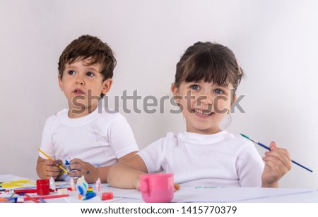Kids playing and painting at home or kindergarten or playschool. Art, creative, early childhood education to children concept. 