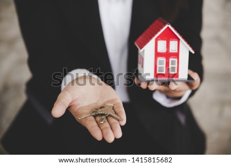 Real estate agent with house model and keys 