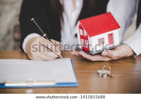Female hand signing business document, female putting signature on legal paper making investment.