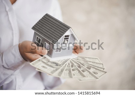 mortgage, investment, real estate and property concept - close up of home model on dollar money 