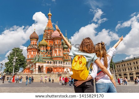 Two happy young happy girls travels in Russia and taking selfie in front of the St Basil Cathedral Royalty-Free Stock Photo #1415829170