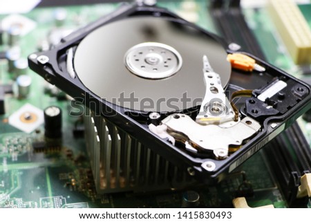 The abstract image of inside of hard disk drive on the technician's desk and a computer motherboard as a component. the concept of data, hardware, and information technology