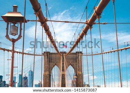 Brooklyn Bridge, American Flag, Cloudy Blue Sky Background. New York City