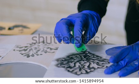 Stencil painting: close up shot of woman hands painting wooden circle. Paint, handmade and crafting work concept Royalty-Free Stock Photo #1415894954