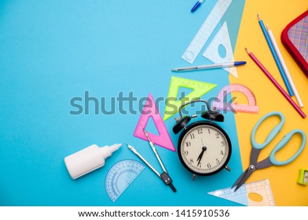 Starting school, back to school, education are styled flat lay scene with school supplies on blue and yellow background. Copy space