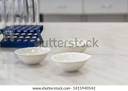 
orcelain cups for evaporation of liquids standing on the table in the laboratory Royalty-Free Stock Photo #1415940542