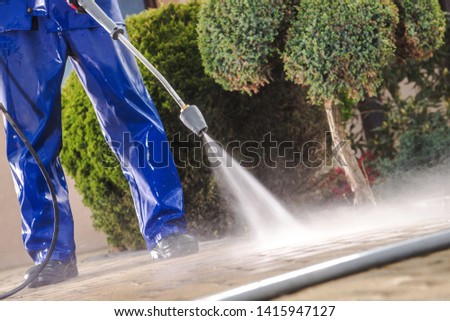 Men Washing Garden Residential Brick Paths with Professional Pressure Washer Royalty-Free Stock Photo #1415947127