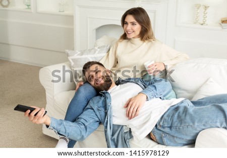 Loving Couple Watching Tv Together, Relaxing On Sofa At Home
