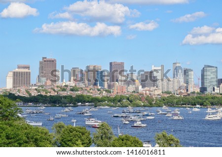 Ships, boats, and yachts are floating in Charles river on 4th of July or independence day in Boston, Massachusetts, USA. Beautiful cityscape on the background.