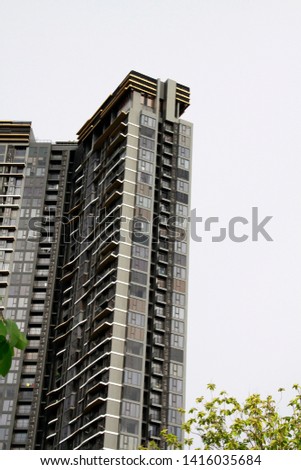 High-rise building behind green leaves