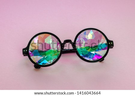 Designer glasses with kaleidoscope lenses. Pink background	

