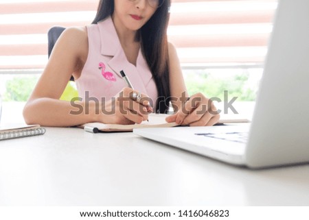 young beautiful businesswoman working and reading content with desktop computer sitting near window in office,business concept
