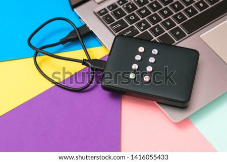 External hard drive labeled database connected to laptop on bright background. The view from the top. The concept of backup storage. Flat lay.