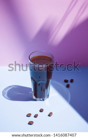 Coffee concept. Coffee drink and coffee beans on a pastel background. A glass of black coffee on a pink blue background. Pop art still life
