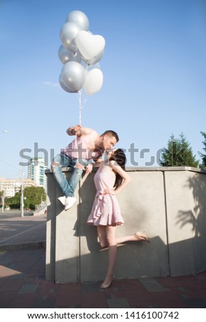 couple in love walking with balloons in summer outdoor.