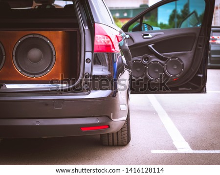 Rear View of a Car, Trunk and Front Door Open, With Installed Car Audio System, Sound Speakers and Giant Subwoofer Sound Speaker. Royalty-Free Stock Photo #1416128114