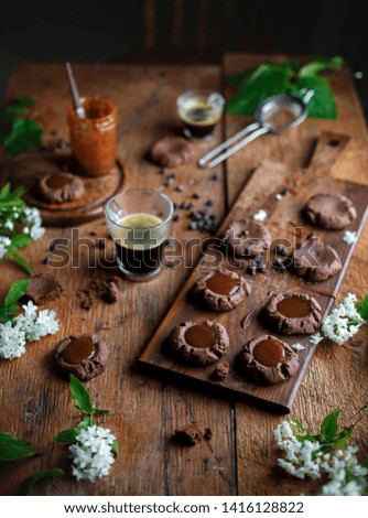 Chocolate cookies with caramel on the rustic black background, coffee cup