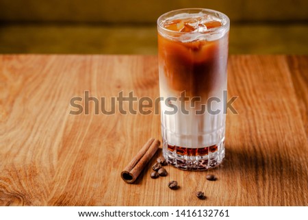 Iced coffee with ice. Frappe with cream and cinnamon on a wooden table. copy space